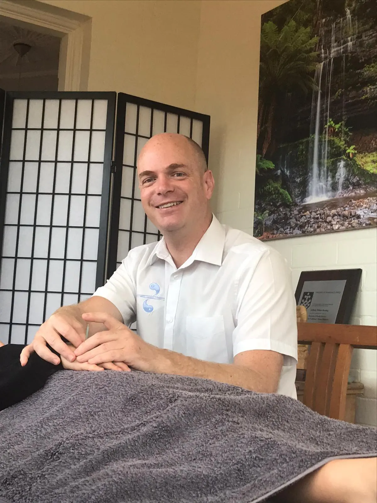 Anthony Keating sitting beside his treatment table